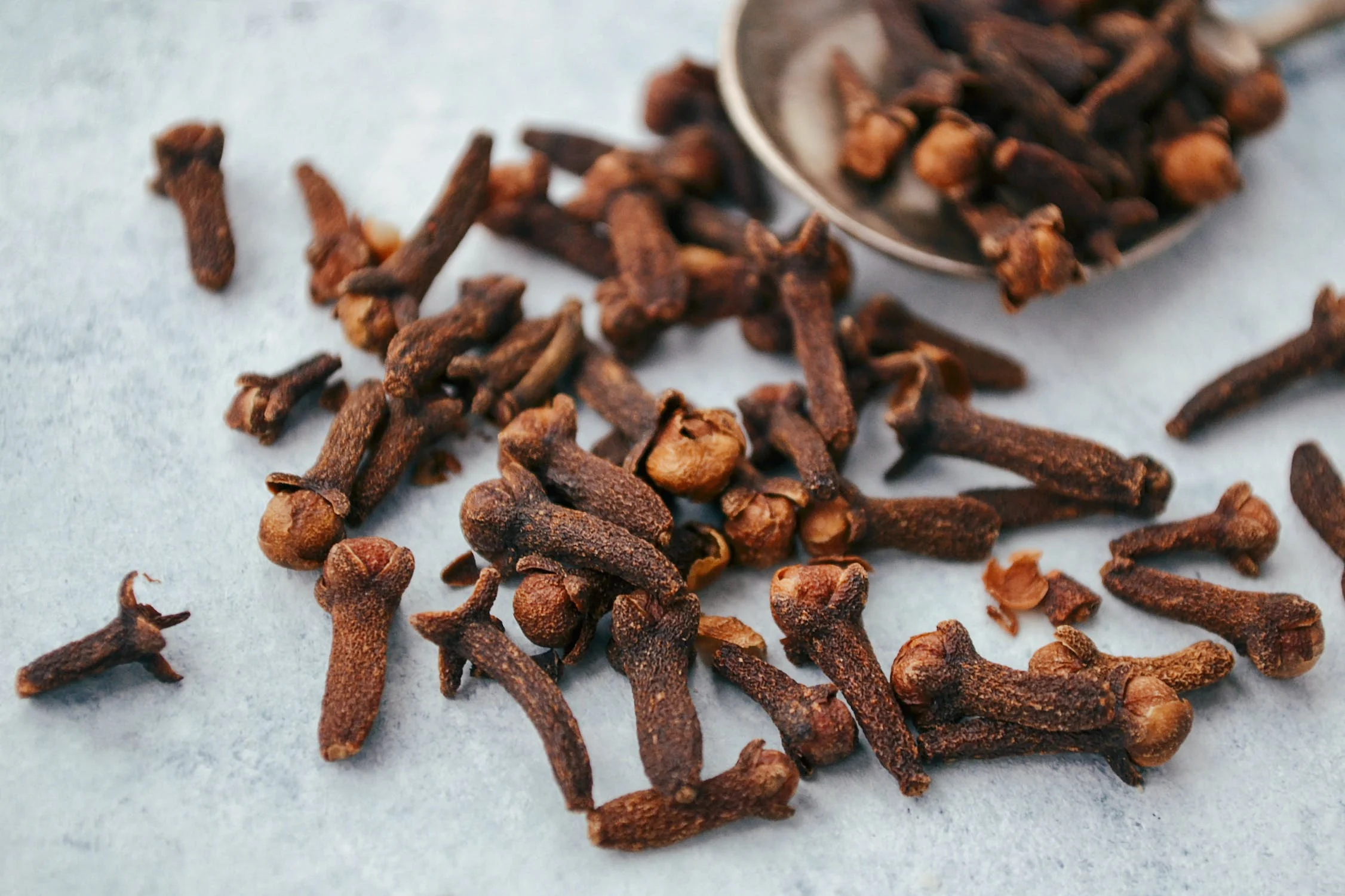 Cloves and a spoon scattered on a table