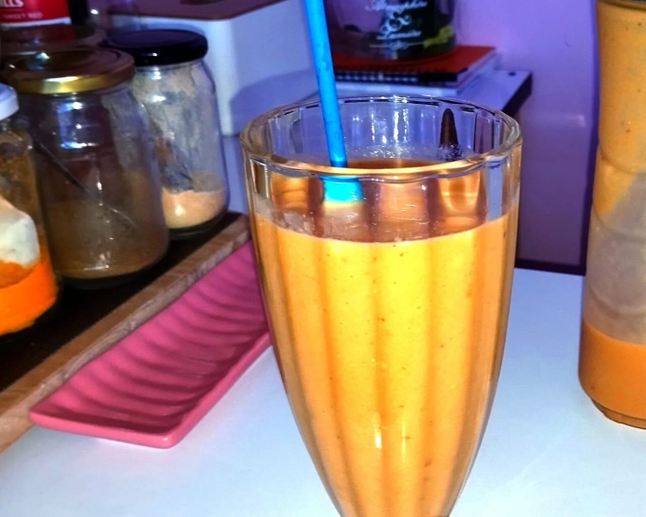 A refreshing smoothie with a straw on a counter.